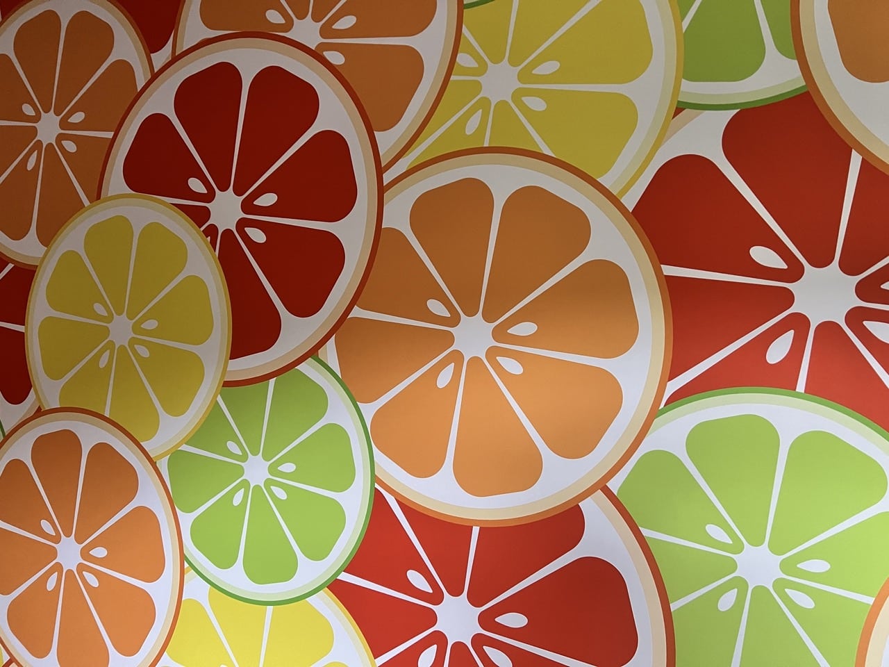 ein Beispiel für die Möglichkeiten der werbetechnischen Raumgestaltung mit einem Textildruck im Alu Rahmen. Das Motiv sind grossformatige, grafische Darstellungen von Zitronen, Limetten, Orangen und Grapefruit Scheiben